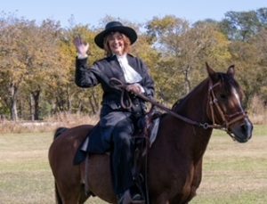 Photo of pastor in period costume on horse.