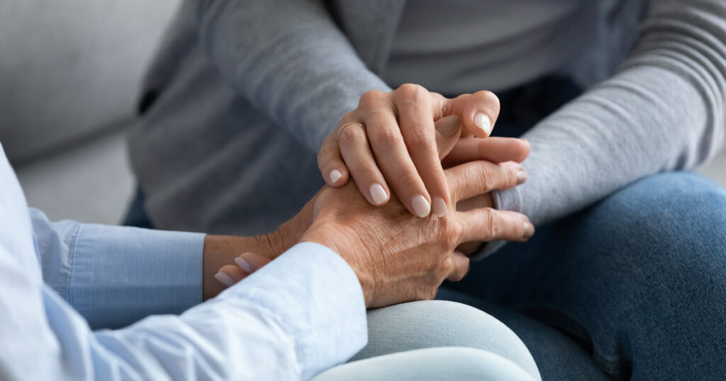 Photo of hands comforting another